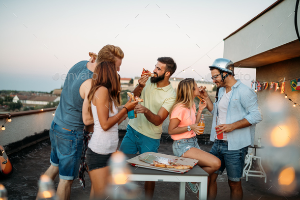 Group of happy friends having party on rooftop Stock Photo by nd3000