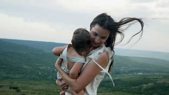 Mom Walks with Her Son Standing on the Mountain