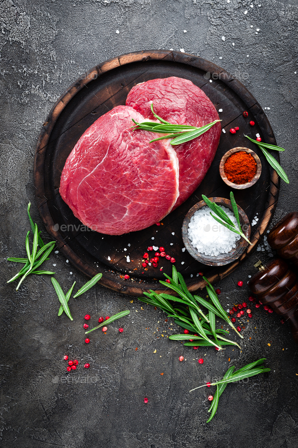 Raw beef meat. Fresh cut of beef meat on board with spices Stock Photo by sea_wave