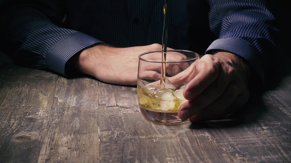 Man Holding a Glass of Ice and Pour Whiskey