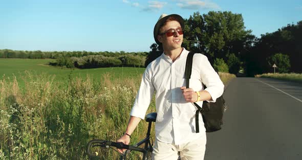 Male Walking with Bicycle in Countryside