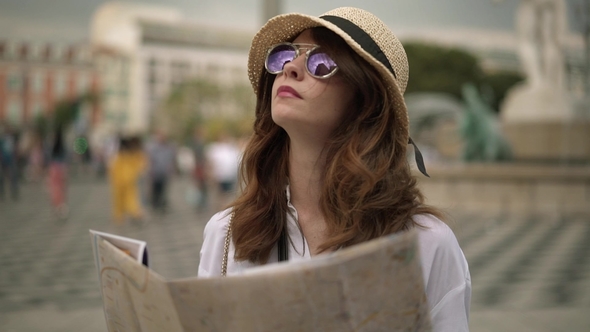 Young Caucasian Tourist with Dark Hair Standing with a Map 