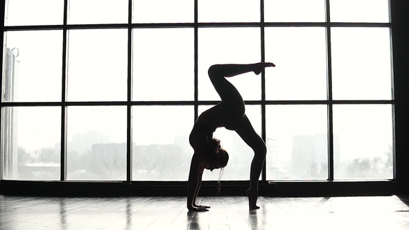 Silhouette of a Gymnast Doing a Handstand in Front of a Big Window