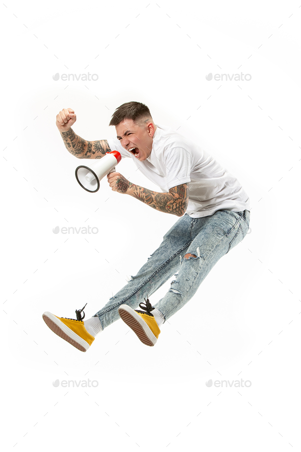 Jumping fan on white background. The young man as soccer football fan with megaphone - Stock Photo - Images