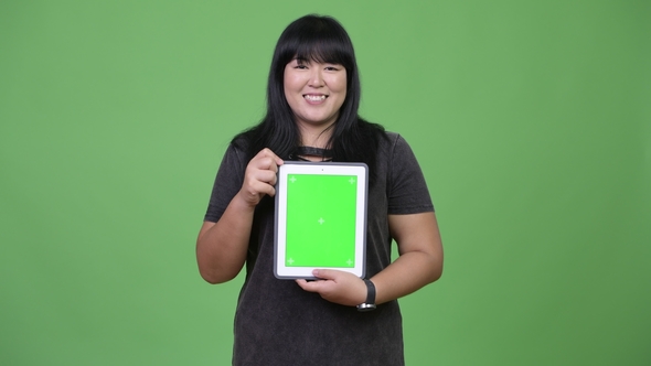 Happy Overweight Asian Woman Showing Digital Tablet alt