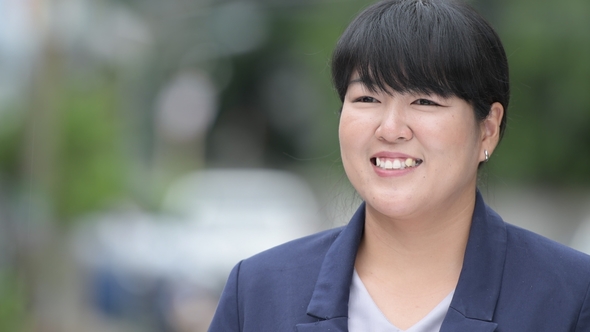 Beautiful Overweight Asian Businesswoman Smiling and Thinking Outdoors