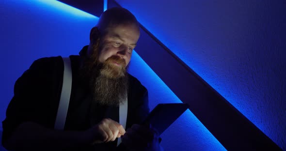 Bearded Man is Surfing the Internet While Using Tablet