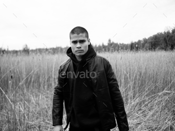 Young man in leather jacket in the wild