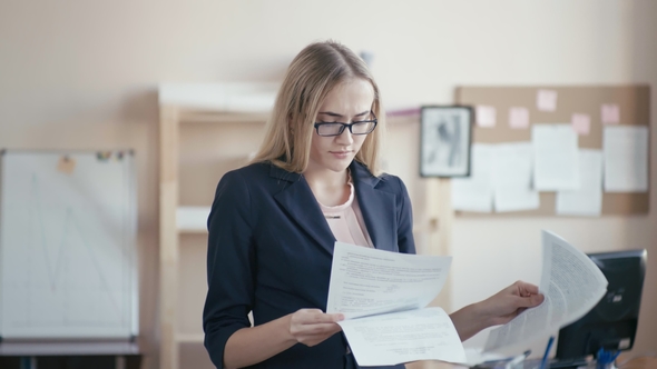 Call Center Employee at Work in the Office. A Young Girl with Blond Hair with Glasses