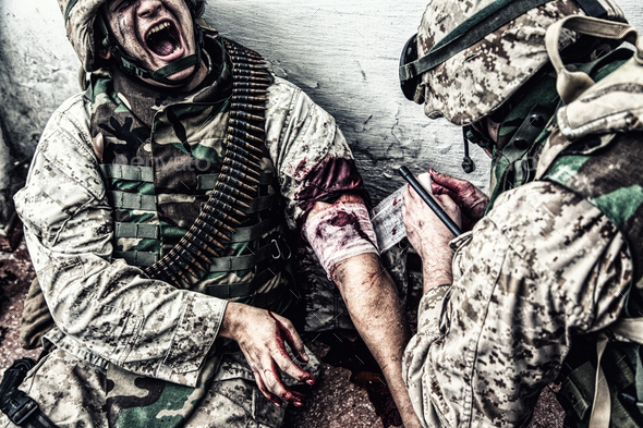 Military medic binding gunshot wound during fight Stock Photo by Getmilitaryphotos