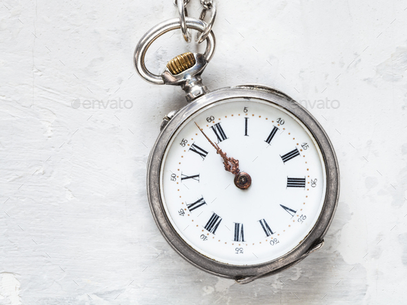 two minutes to twelve on antique watch on concrete Stock Photo by vvoennyy