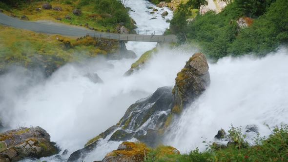 Stormy Waters of the Waterfall, at the Bottom of the Bridge in the Distance alt