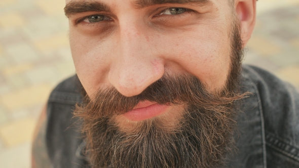 Face of a Bearded, Brutal and Smiling Man in the Street alt