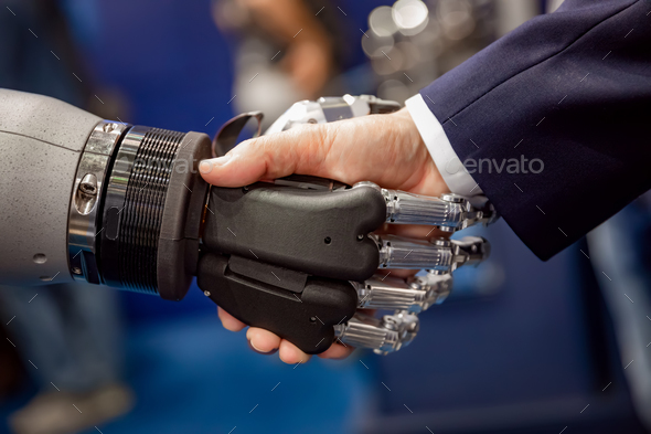 Hand of a businessman shaking hands with a Android robot. Stock Photo by cookelma