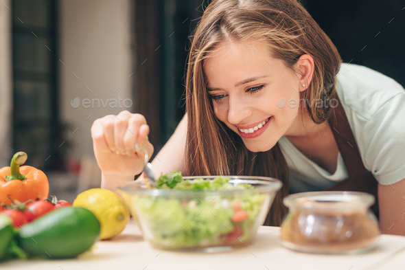 Smiling young woman in the kitchen - Stock Photo - Images