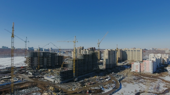 Construction of a New Residential Area in Front of Road Traffic Covered in Snow alt