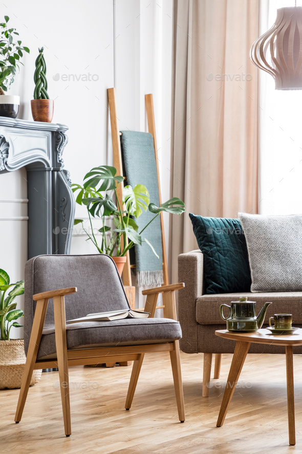 Real photo of a chair standing next to a coffee table and a sofa - Stock Photo - Images