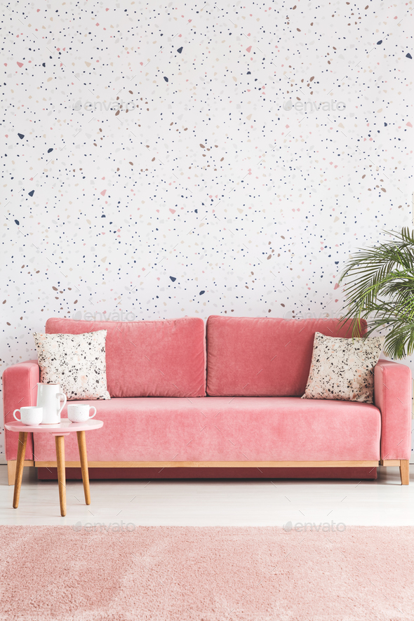 Pillows on pink sofa against lastrico wallpaper in living room i Stock Photo by bialasiewicz