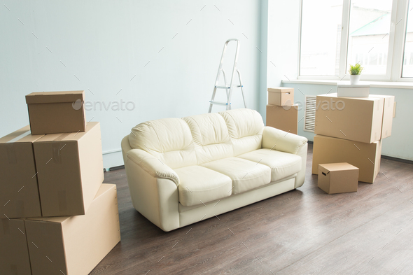New white sofa in empty room between an amount of boxes Stock Photo by Satura_