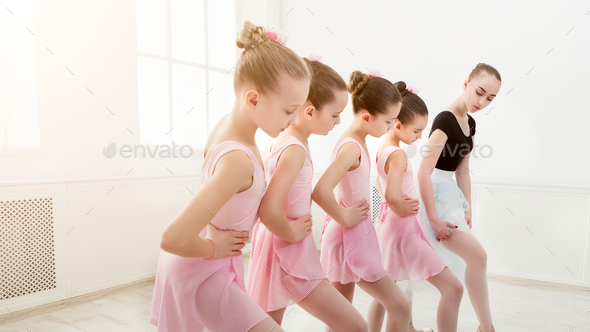 Teacher helping her students during dance class Stock Photo by Prostock-studio
