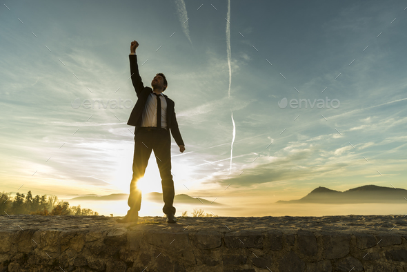 Triumphant businessman greeting a new day - Stock Photo - Images