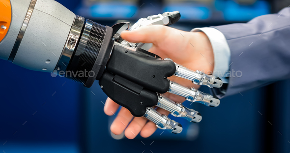 Hand of a businessman shaking hands with a droid robot. The conc - Stock Photo - Images