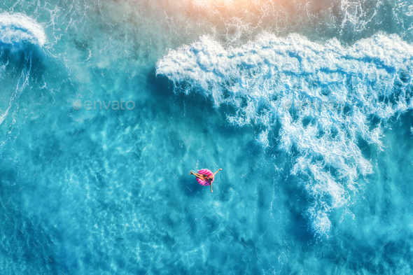 Aerial view of slim young woman swimming on the donut swim ring - Stock Photo - Images