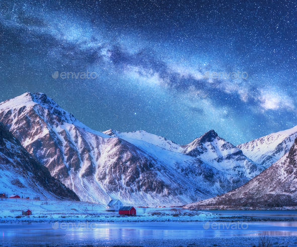 Milky Way above houses and snow covered mountains in winter Stock Photo by den-belitsky