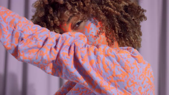Mixed Race Woman with Curly Hair and Bright Neon Makeup Pattern on the Face the Same Like on Her