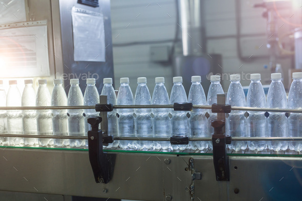 Water bottling line for processing and bottling pure mineral water into small bottles Stock Photo by Satura_