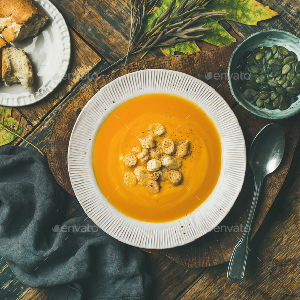 Warming pumpkin cream soup with croutons and seeds, square crop - Stock Photo - Images