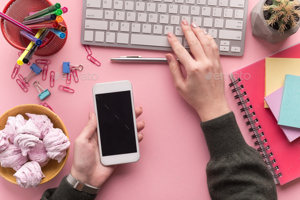 Female hands typing on laptop keyboard and holding smartphone - Stock Photo - Images