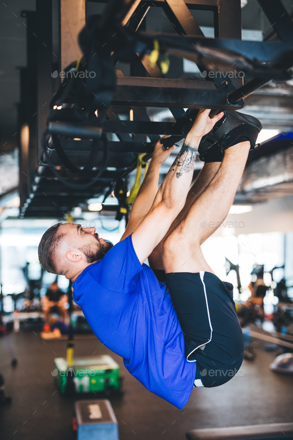 Man pulling his body up on the rig at the gym. Stock Photo by photocreo