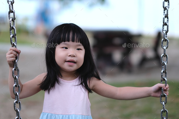 Portrait of a little asian girl in swing - Stock Photo - Images