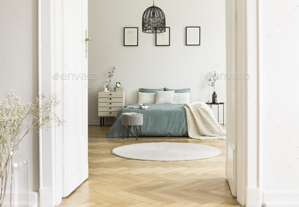 Real photo of white bedroom interior with round rug, king-size b Real photo of white bedroom interior with round rug, king-size b