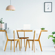 Pink lamp above wooden chairs at table in white interior with po - $5.00 Pink lamp above wooden chairs at table in white interior with po