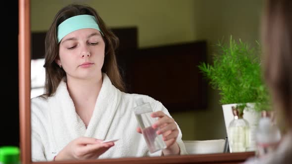 4k Happy attractive young woman applying a tonic at her pretty face alt