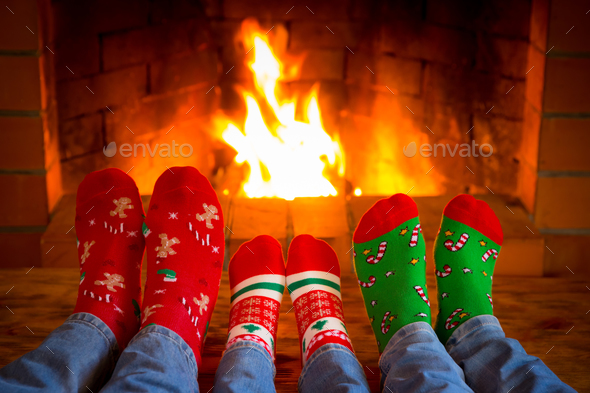 Family in Christmas socks near fireplace - Stock Photo - Images