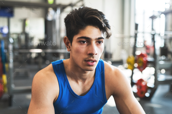 A close up of a young man in crossfit gym, resting after an exercise. Stock Photo by halfpoint