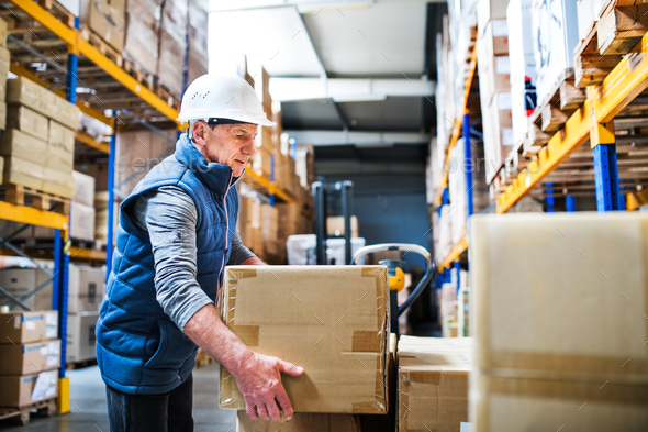 Senior male warehouse worker unloading boxes from a pallet truck. - Stock Photo - Images