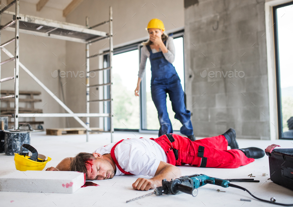 A woman found man worker lying unconscious on the floor at the construction site. Stock Photo by halfpoint