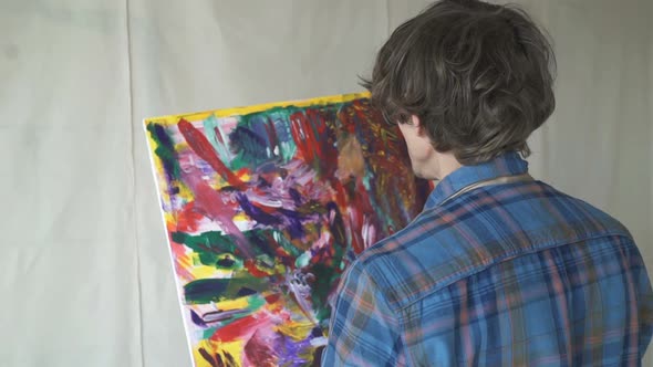The Artist Paints on Canvas and Smears a Brush. Canvas Stands on the Easel.