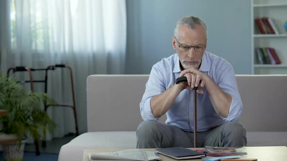 Old Man Sitting on Sofa at Nursing Home and Thinking About Life, Sadness alt