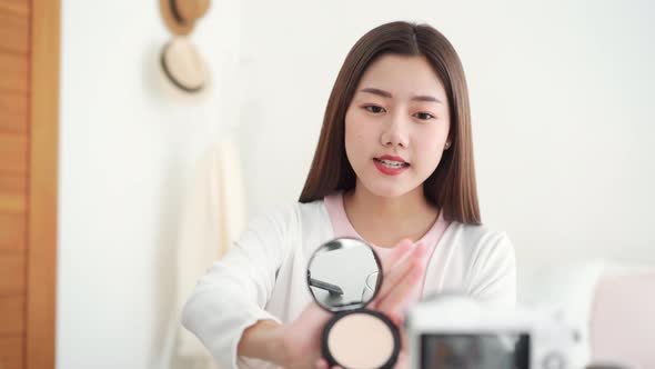 Asian woman professional beauty influencer doing cosmetic review live streaming online
