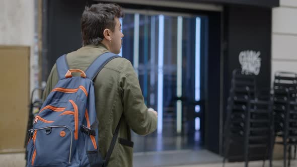 Close Up Shot Taken of a Male Magician Wearing a Blue Backpack While Walking Trying to Find a alt
