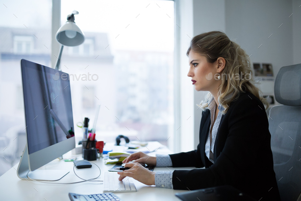 Attractive young female architect working on laptop Stock Photo by nd3000