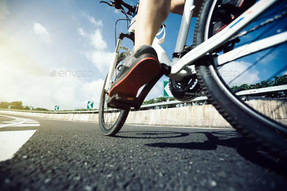 Legs cycling on highway Stock Photo by lzf | PhotoDune