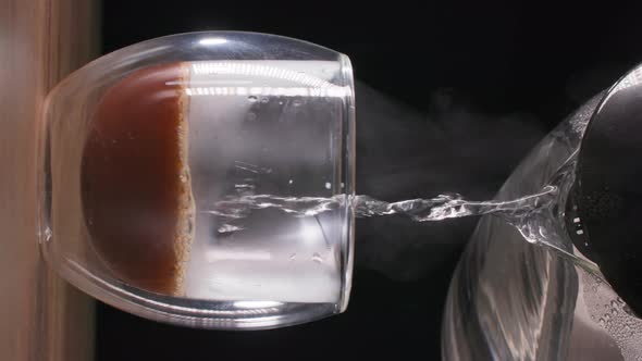 Hot Steaming Water is Poured Into Instant Grains to Obtain a Coffee Drink in a Transparent Glass alt
