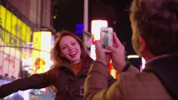 Couple taking photos in Times Square, New York City