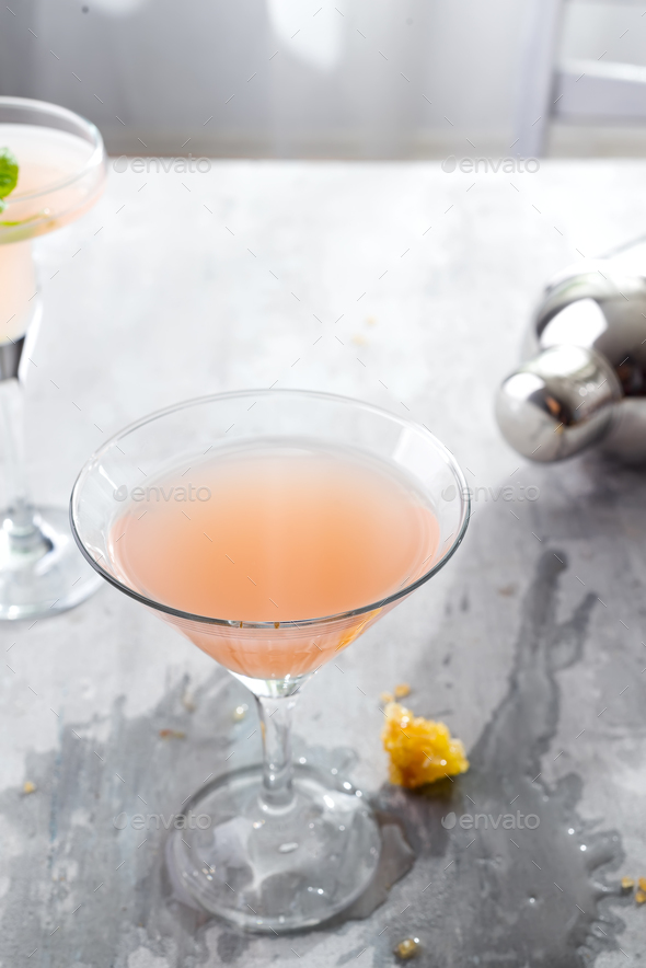 Bellini cocktail with peach and honey , with a spilled beverage on a concrete background Stock Photo by lyulkamazur
